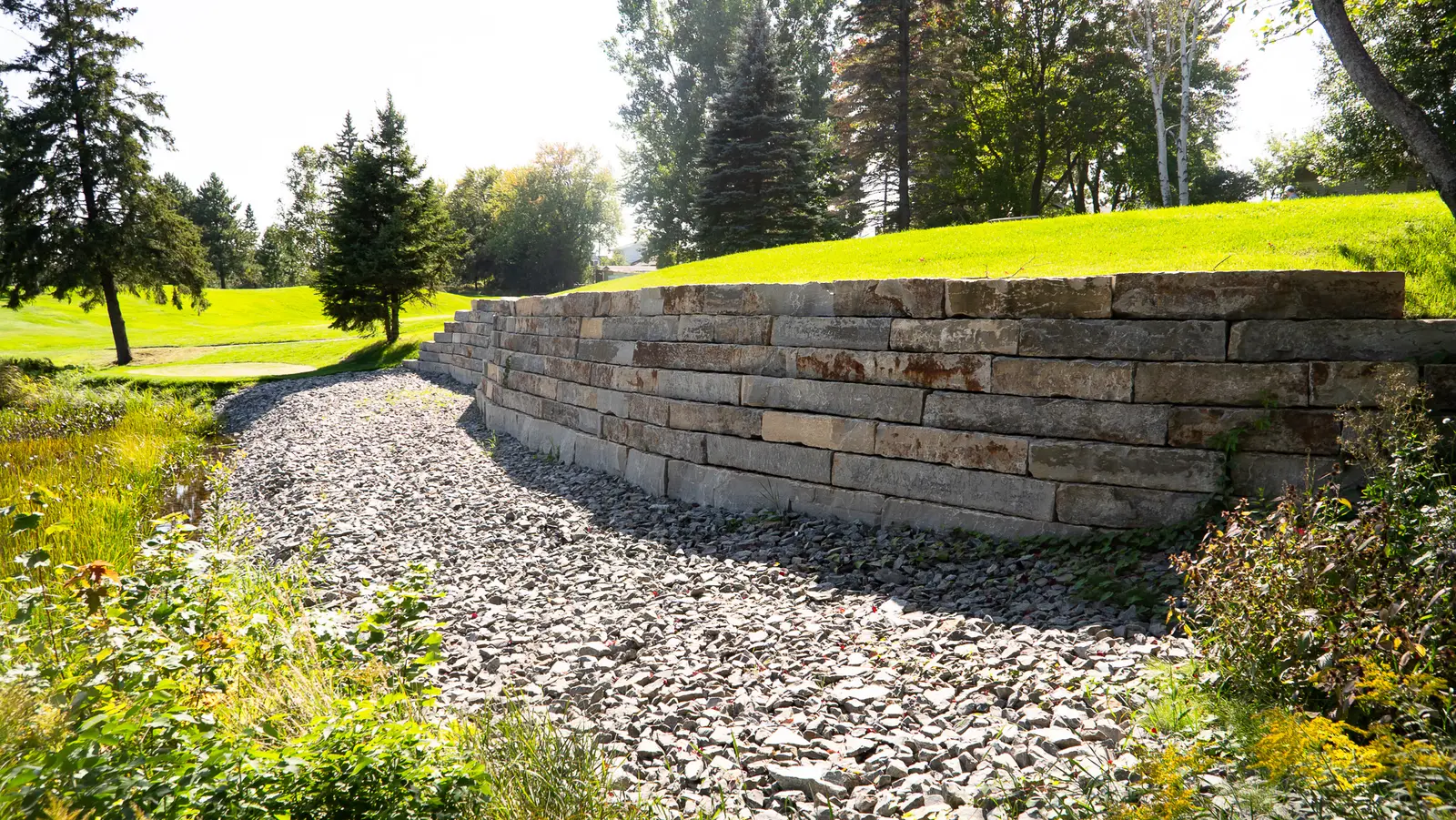 Curved armour stone retaining wall built for shoreline protection with Lime Kiln Quarry stone