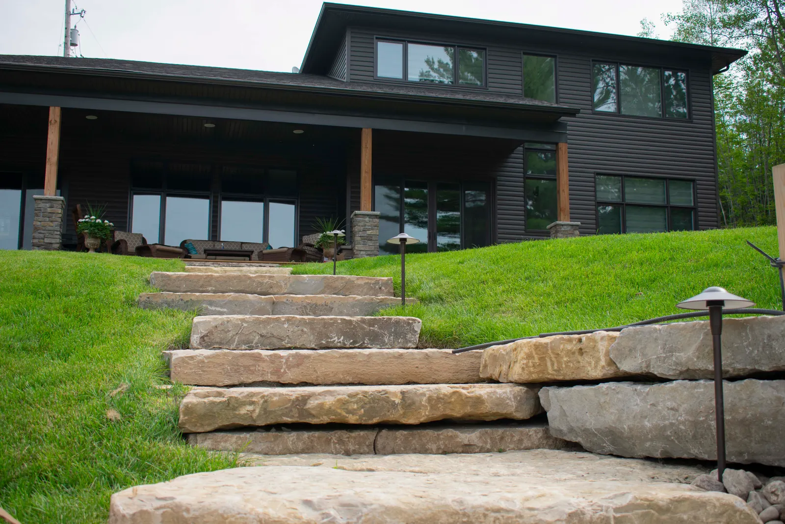 Natural stone steps leading up to the lakefront house, with integrated path lighting