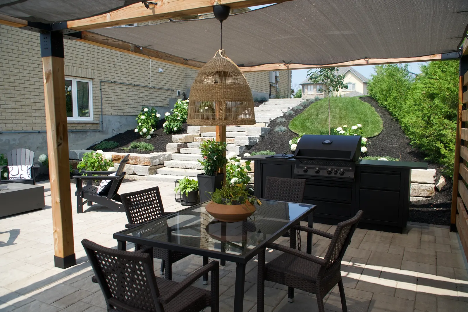 Pergola-covered patio with outdoor kitchen and dining area
